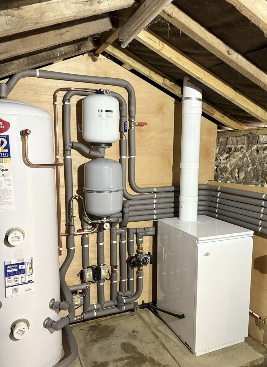 Neatly insulated heating pipework, expansion vessels and cylinder in a plant room